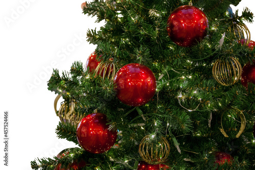 Fragment of a Christmas tree, decorated with balls and garlands with lights. Close-up. White background