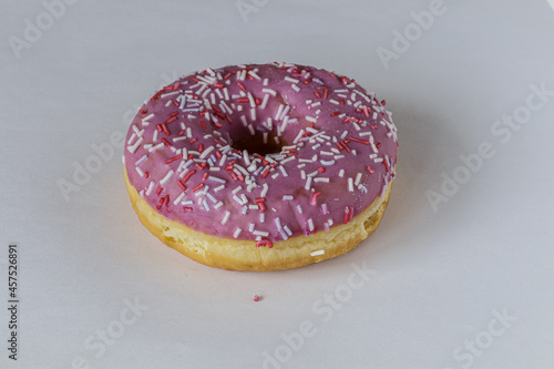 Tasty glazed raspberry donut with topping.