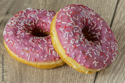Tasty glazed raspberry donut with topping.