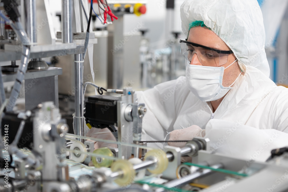 male engineers wearing personal protective equipment uniform(PPE) and medical face mask, checking machine in laboratory male engineers wearing personal protective equipment uniform(PPE) and medical face mask, checking machine in laboratory