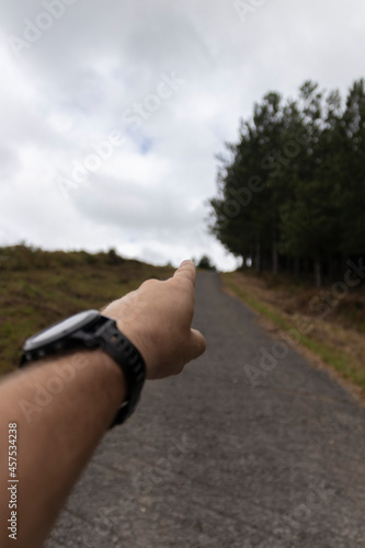 hand pointing to the horizon on a trail high on a hill
