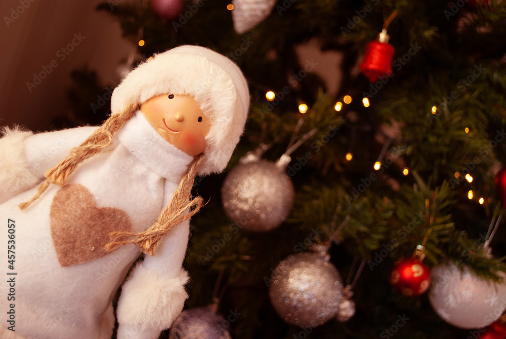 Obraz premium doll, girl in a fur coat and hat, snow maiden, Christmas decor, toys, bows, glass balls, bokeh, background, toys, merry christmas, happy new year. Lights, sparkles and highlights, snow, Christmas tree