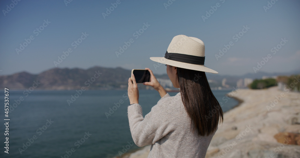 Woman use smart phone to take photo at landscape