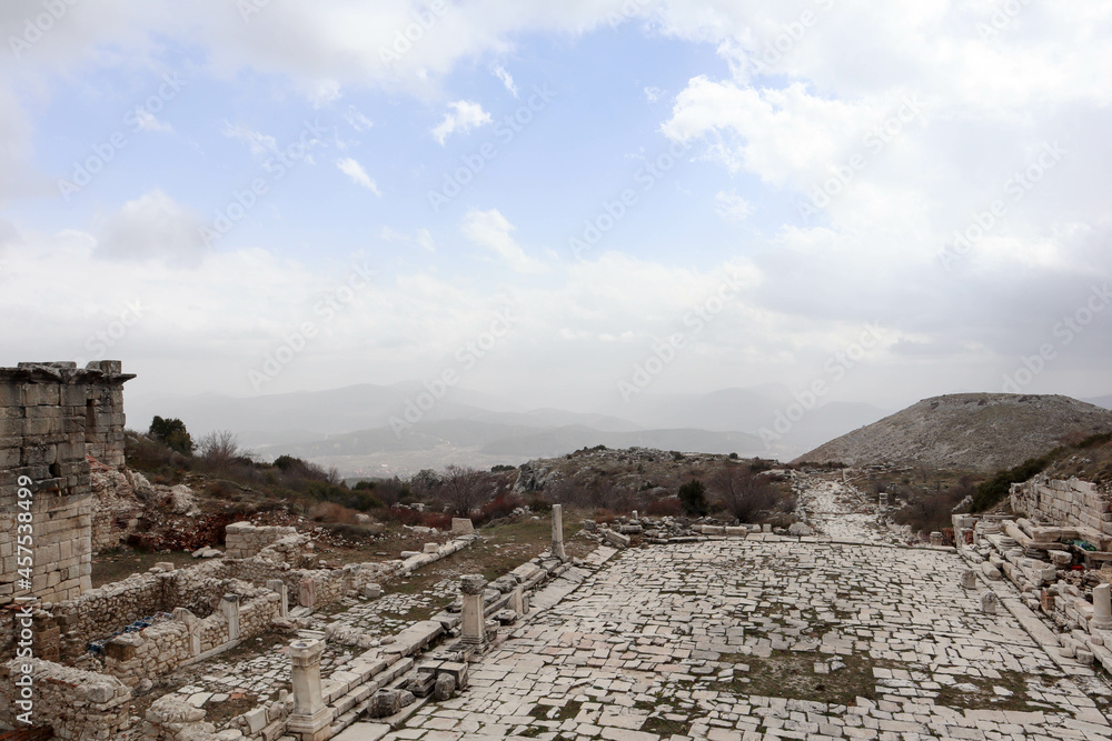 Fototapeta premium grand colonnaded street with white marble pavement in ruins of the ancient city Sagalassos lost in Turkey mountains