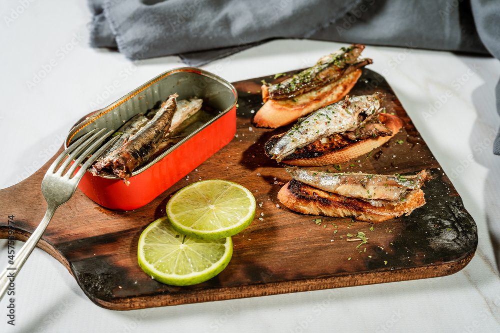 Arrangement of Spanish tapas of sardines in olive oil on toasts on a