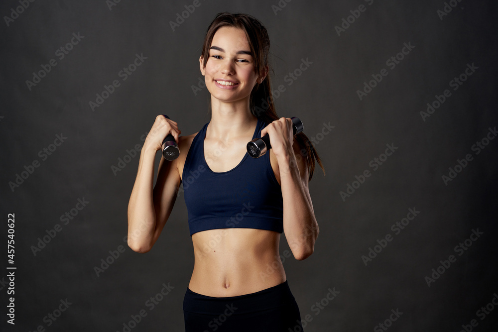 athletic woman fitness exercise dumbbells in the hands of Strong isolated background athletic woman fitness exercise dumbbells in the hands of Strong isolated background
