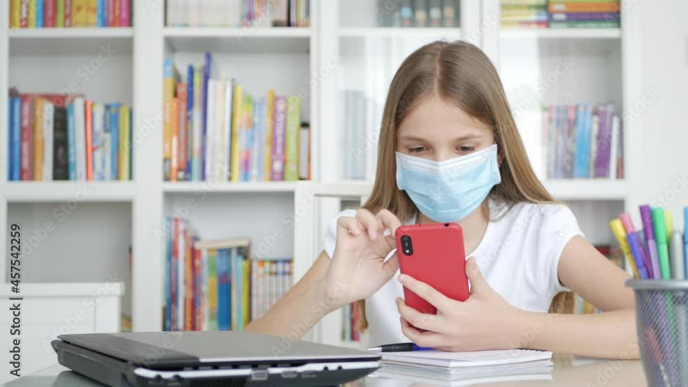 Kid with Protective Mask Studying on Smartphone in Coronavirus Pandemic, Child Learning, Student Girl on Devices Online Education Kid with Protective Mask Studying on Smartphone in Coronavirus Pandemic, Child Learning, Student Girl on Devices Online Education