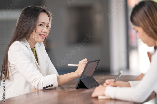 Young Asian college students have meetings with a teacher advisor or a tutor to discuss the project