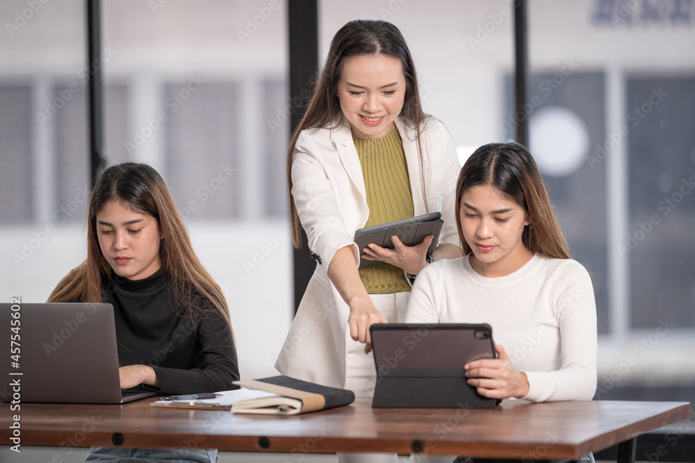 Young Asian college students have meetings with a teacher advisor or a tutor to discuss the project Young Asian college students have meetings with a teacher advisor or a tutor to discuss the project