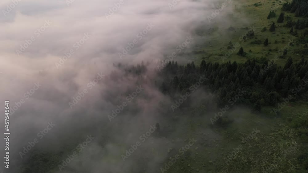 Drone flyght over flowing morning fog in summer mountains. Beautiful sunrise light glowing on forest, medows and green hills. UHD 4k video Drone flyght over flowing morning fog in summer mountains. Beautiful sunrise light glowing on forest, medows and green hills. UHD 4k video