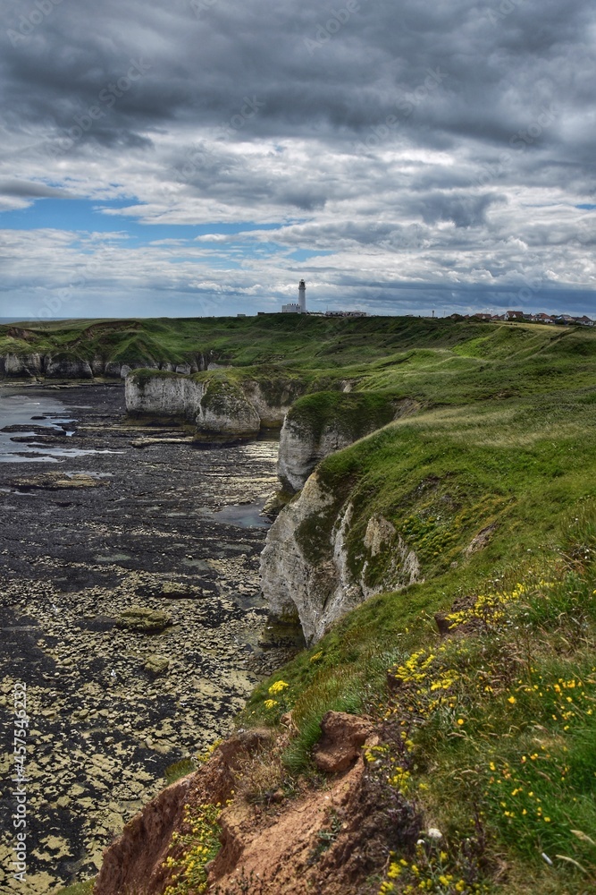 landscape with sea and cliffs and a lighthouse in then distance. Taken in Yorkshire England. 