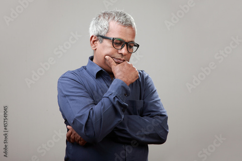 Mature man of Indian ethnicity with a thinking face
