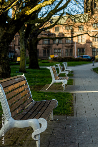 Landscape of old benches in the foreground with blurry buildings in the background. © Nicolae