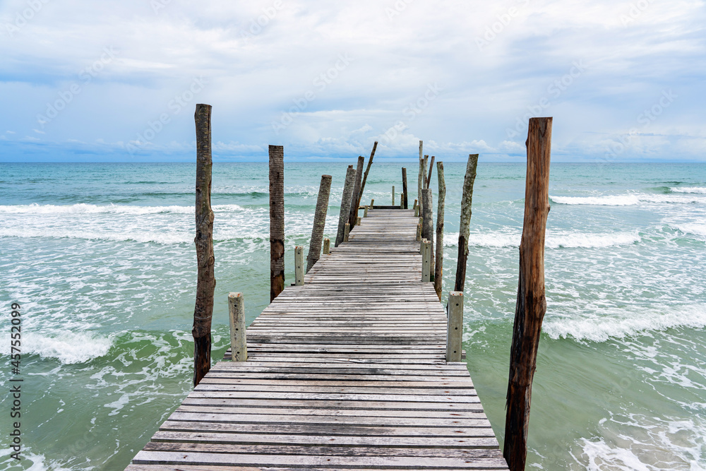 Wooden pier with sea waves and blue sky background Wooden pier with sea waves and blue sky background