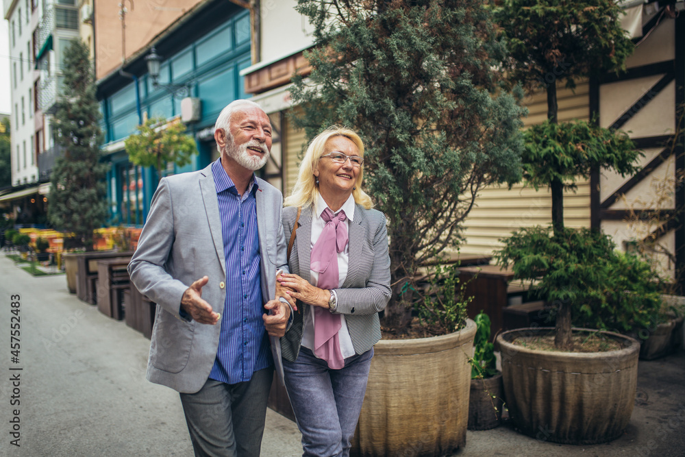 Fototapeta premium Mature married couple are walking through a city together.