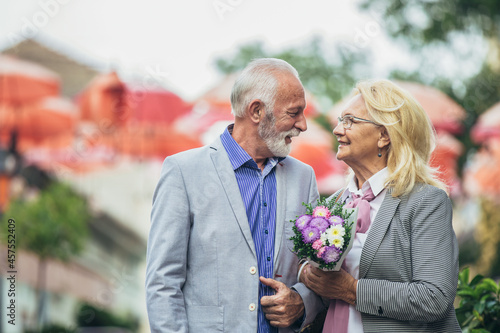 Mature married couple are walking through a city together.