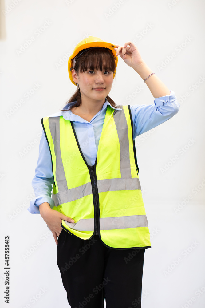 Portrait of young asian woman worker wearing safety vest and hardhat helmet workingin warehouse. logistic and business import export.