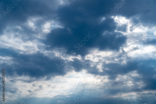 Fototapeta Naklejka Na Ścianę i Meble -  Dark sky with sun coming through cloud. Dramatic cloudscape area with light beams in centre