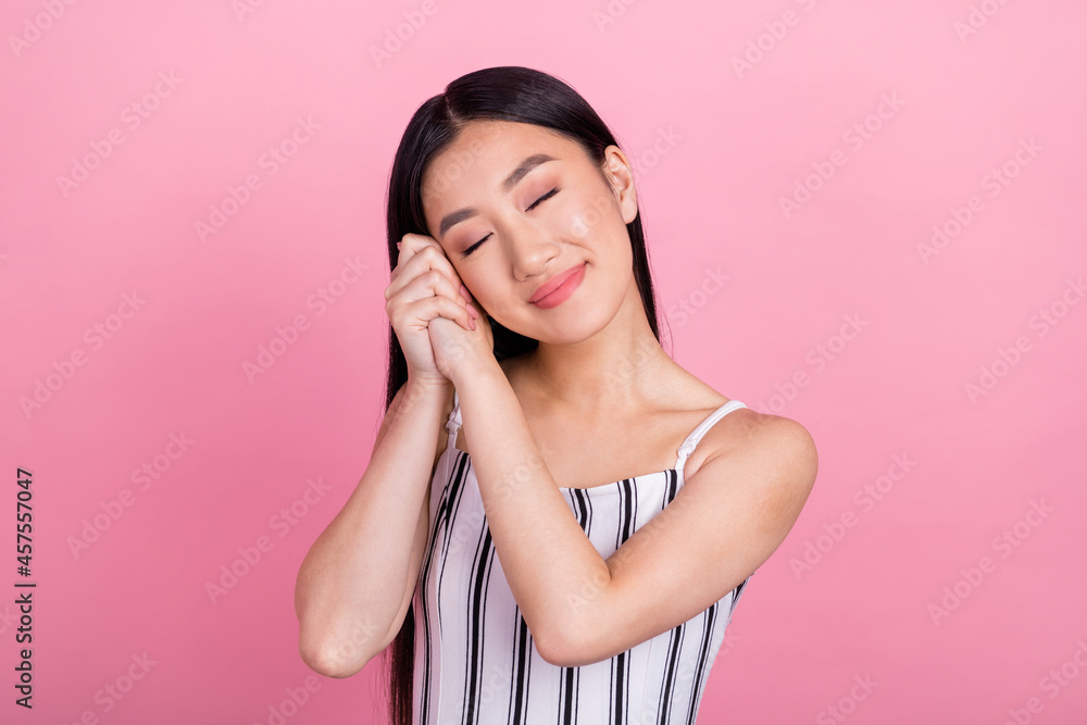 Photo of charming sleepy young woman dressed white clothes arms together cheek closed eyes isolated pink color background Photo of charming sleepy young woman dressed white clothes arms together cheek closed eyes isolated pink color background