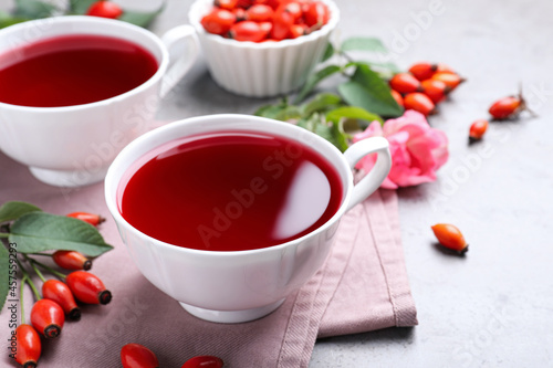 Fresh rose hip tea and berries on light table, closeup