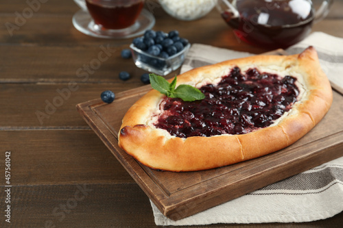 Delicious sweet cottage cheese pastry with cherry jam on wooden table. Space for text