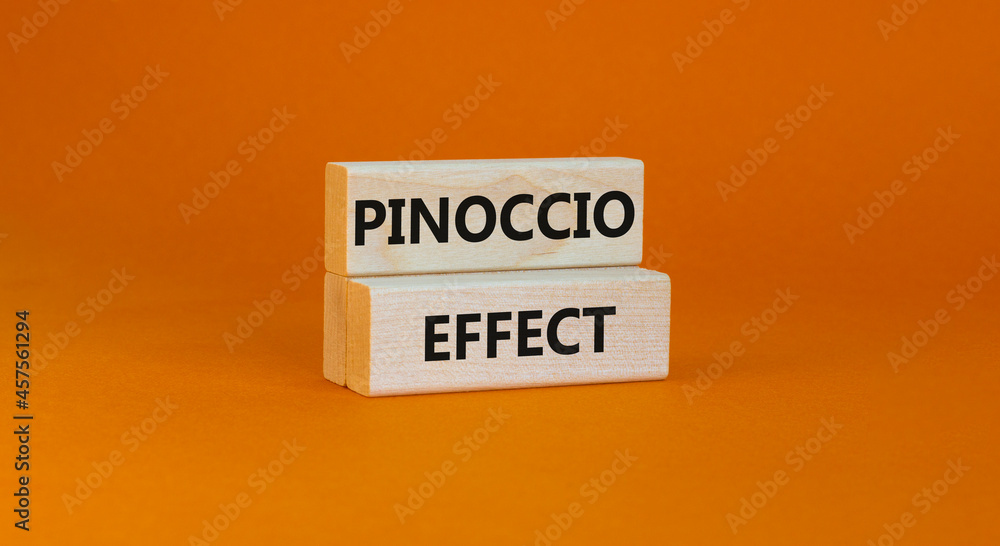 Pinoccio effect symbol. Concept words Pinoccio effect on wooden blocks on a beautiful orange background. Business and Pinoccio effect concept, copy space. Pinoccio effect symbol. Concept words Pinoccio effect on wooden blocks on a beautiful orange background. Business and Pinoccio effect concept, copy space.
