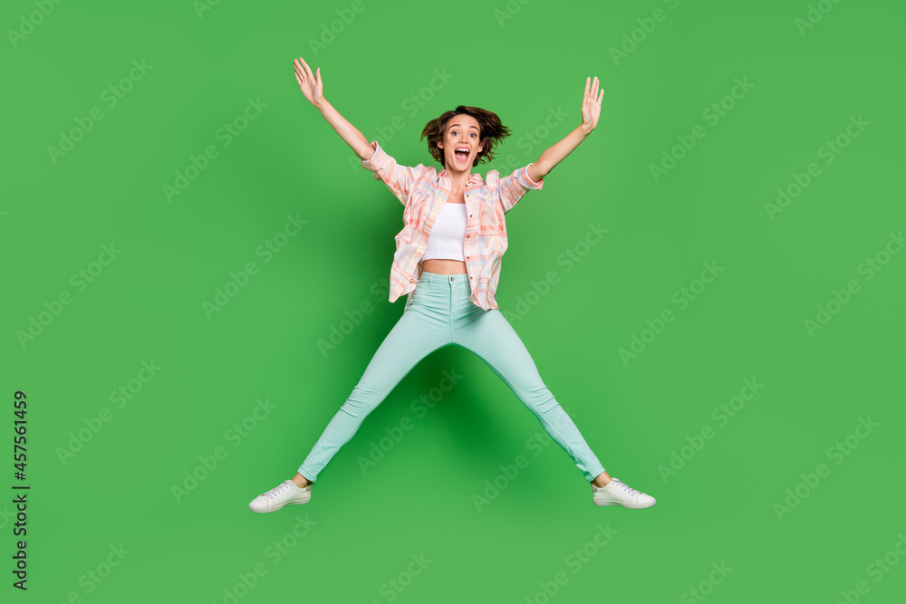 Full body photo of cheerful positive happy young woman jump up star shape sale dream isolated on green color background