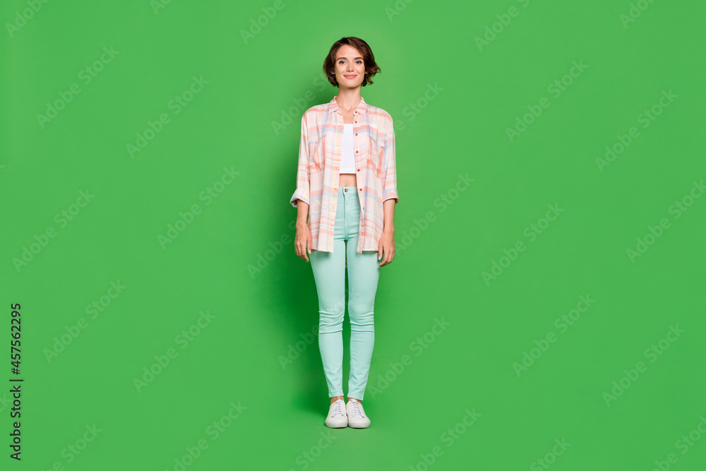 Full length photo of cheerful positive young woman good mood wear casual clothes isolated on green color background Full length photo of cheerful positive young woman good mood wear casual clothes isolated on green color background