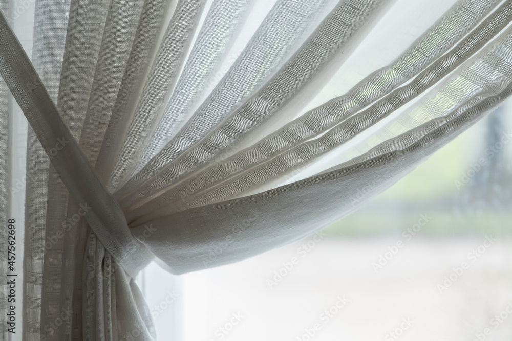 Obraz premium Wavy tulle in front of bright window. Background photo