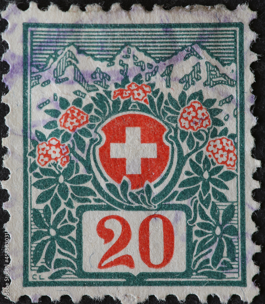 Switzerland - Circa 1911: a postage stamp printed in the Switzerland showing the Swiss coat of arms framed with flowers and high mountains in the background. For non-profit organizations only. No 20