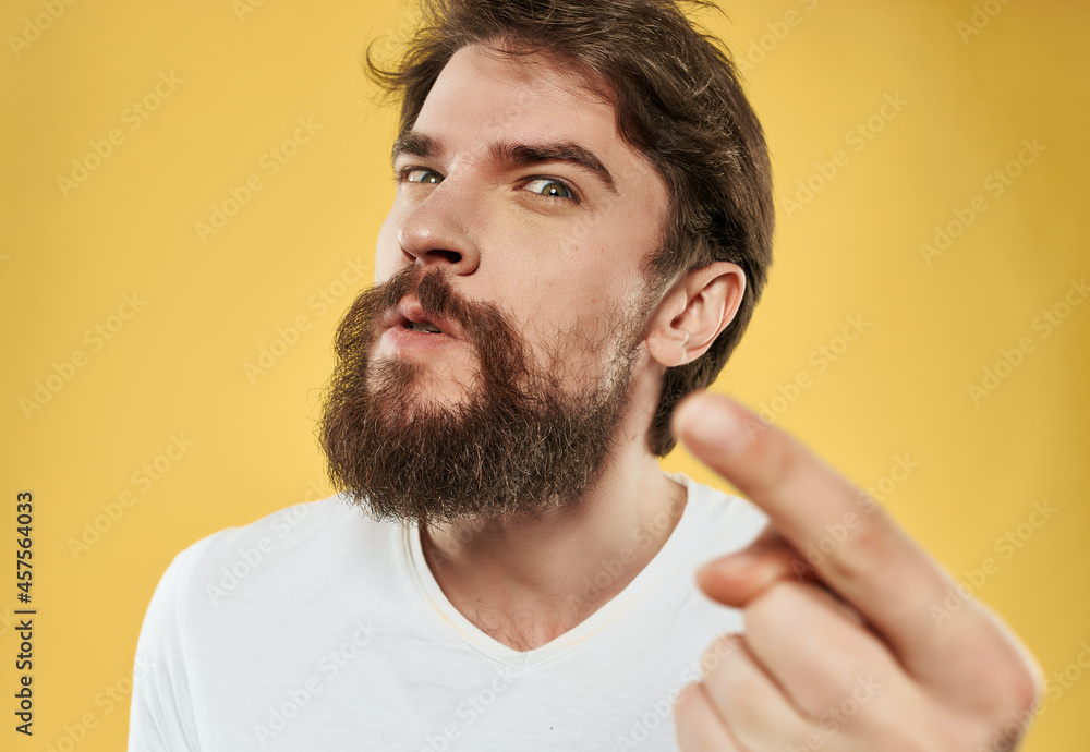 Obraz premium national bearded man in white t-shirt discontent yellow background