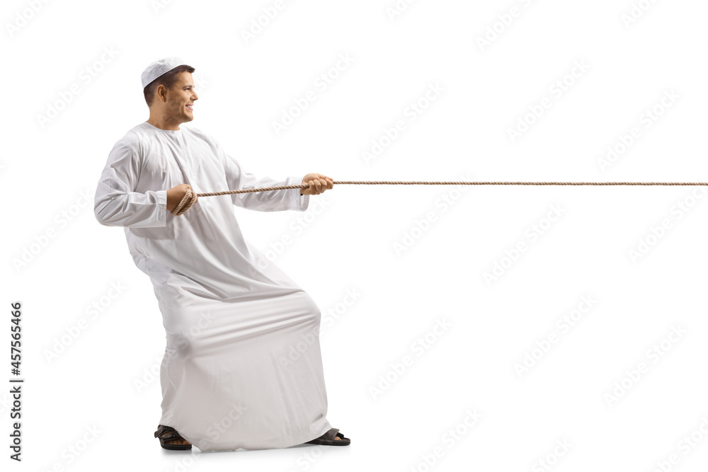 Full length profile shot of a man in ethnic clothes pulling a rope Full length profile shot of a man in ethnic clothes pulling a rope