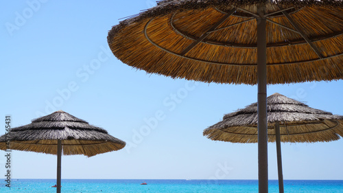 Fototapeta Naklejka Na Ścianę i Meble -  beach straw umbrellas from the sun on the background of the blue sky sea resort vacation summer vacation sun