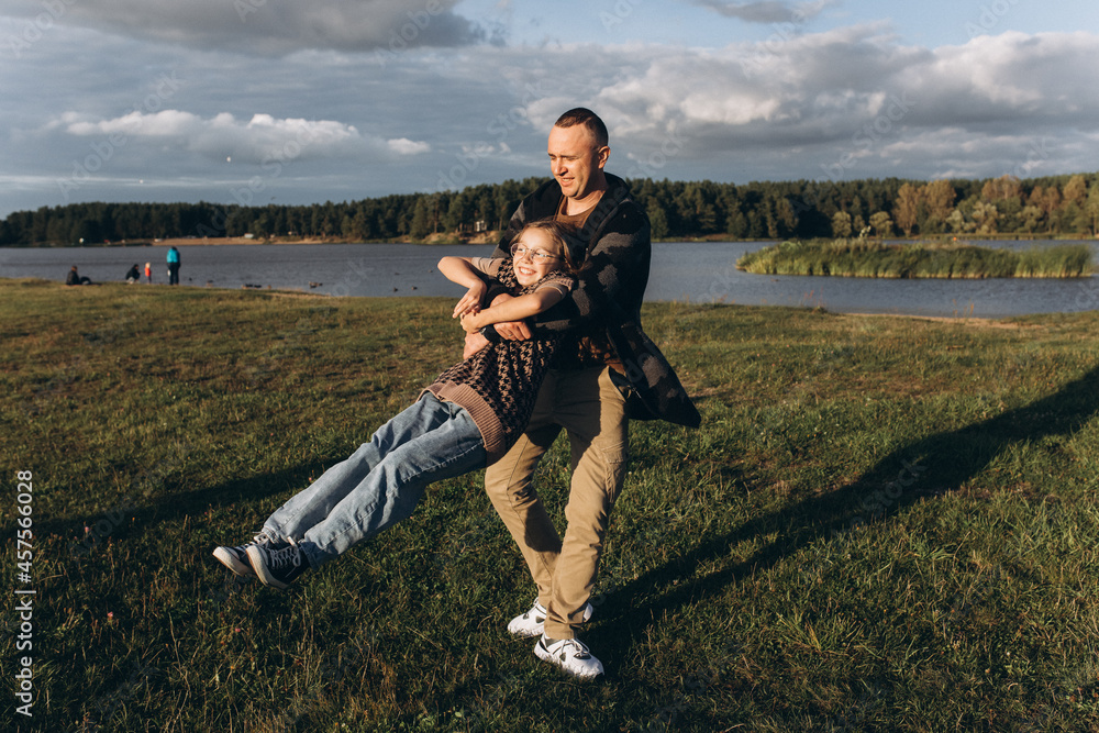 Fototapeta premium Father and daughter share love, have fun in park. Family outdoor vacation together. Happy Father's Day!