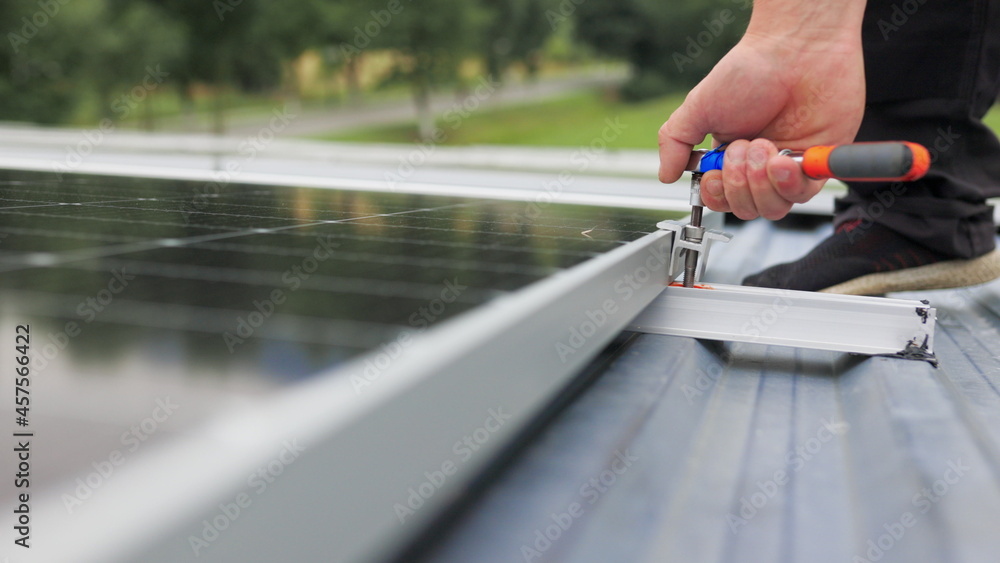 Mounting solar panel, installing solar panels on the roof of the house. Connection of solar panels. Close up of worker installing and working on maintenance of photovoltaic panel system installed. Mounting solar panel, installing solar panels on the roof of the house. Connection of solar panels. Close up of worker installing and working on maintenance of photovoltaic panel system installed.