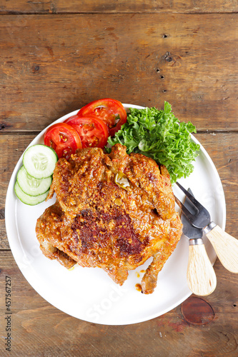 Ayam bakar Taliwang  is a traditional roast chicken from Lombok Indonesia on a wooden background.