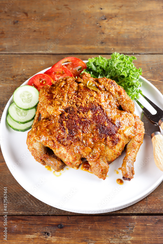 Ayam bakar Taliwang  is a traditional roast chicken from Lombok Indonesia on a wooden background.