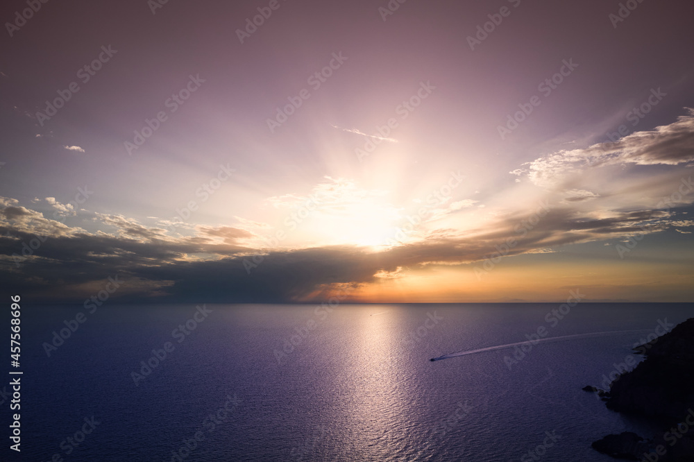 aerial view of a boat plowing the sea at sunset
