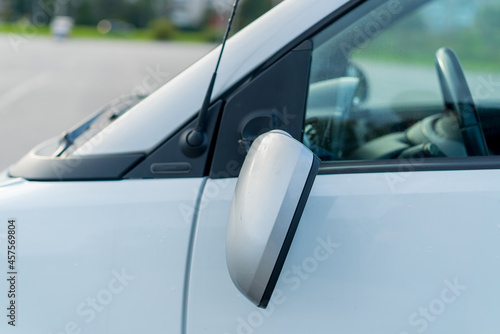Broken off side rearview mirror on car. White automobile on road after accident. © vimpro