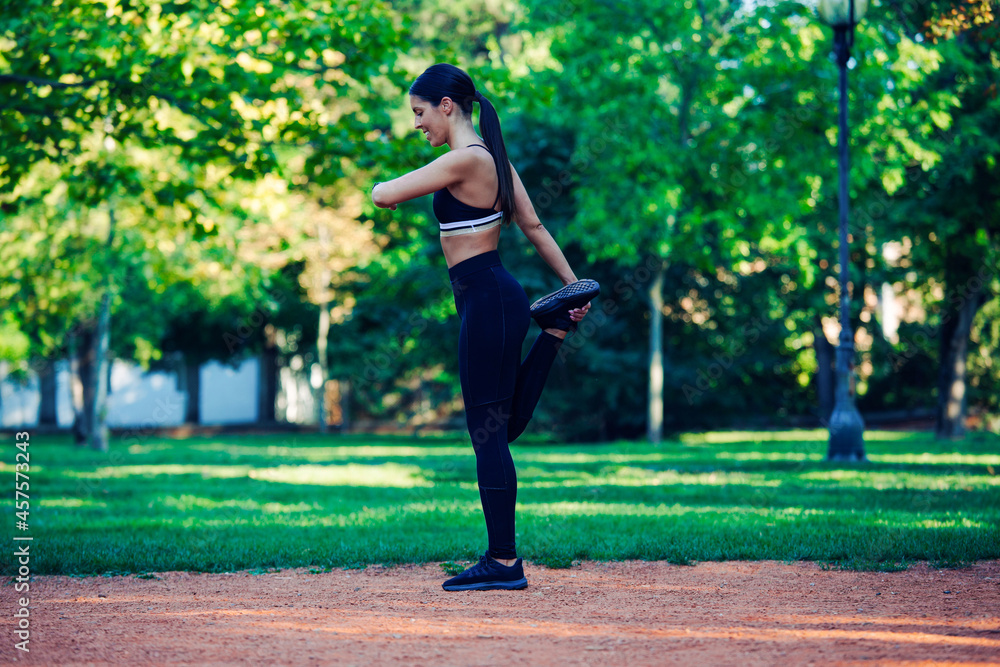 Young woman stretching body after jogging 
