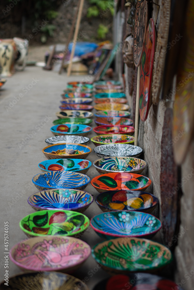 Selective shot of colourful painted bowls lined up on the street at a Mexican market