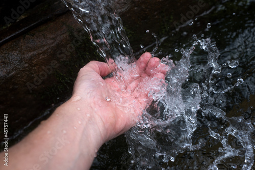 closeup of hands spashing in the water of typical  fountain