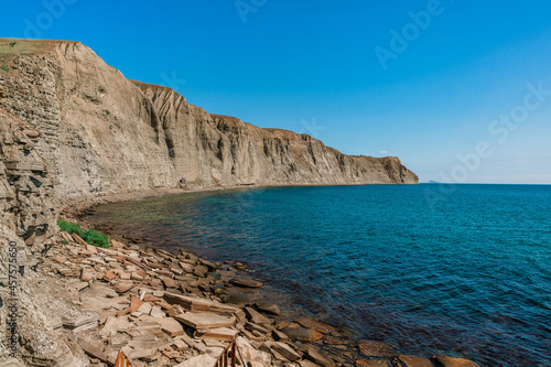 A rocky beach made of natural rectangular stones in the Crimea, a gloomy lifeless landscape