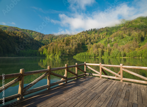 Wooden pier on the lake in the morning sun. Beautiful nature and lake view © daphnusia