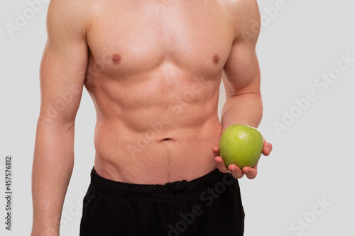 Man Holding Apple Topless. Sportsman with Healthy food in Hands. Muscles, Abs, Biceps, Core. Healthy food, Healthy Eating, Sport, Body, Workout concept