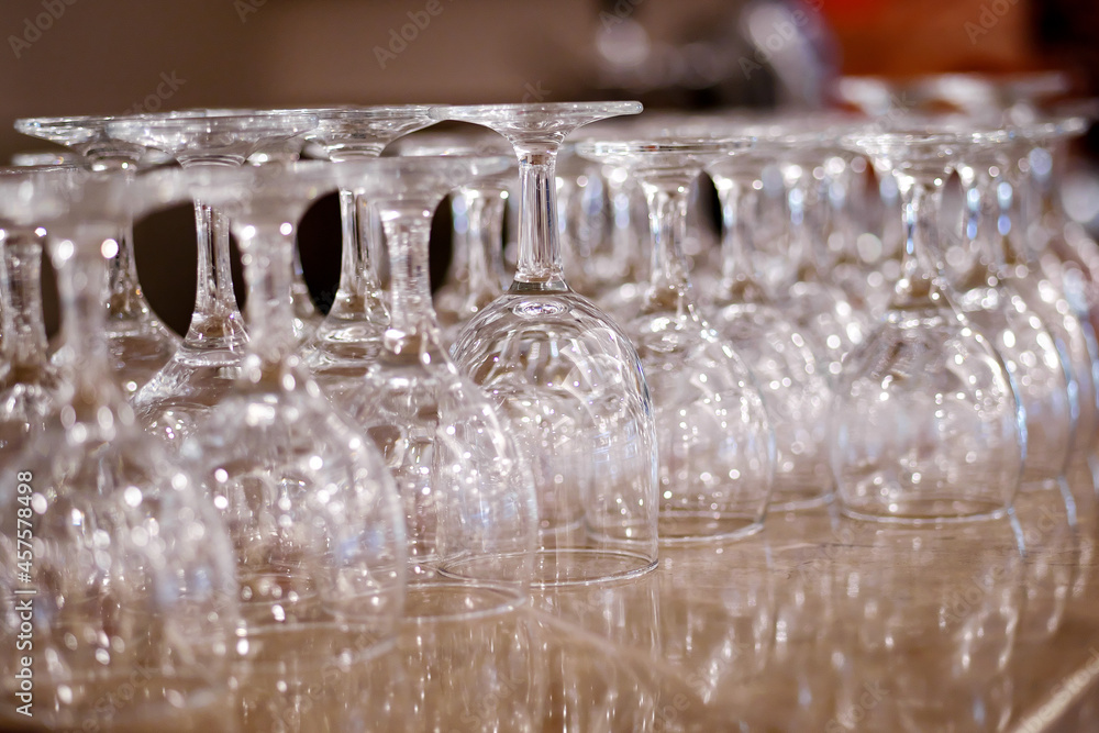 Overturned clean wine glasses on bar counter.