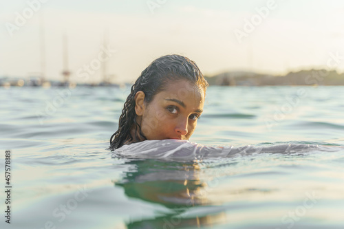 Woman in the sea staring straight ahead. Artistic concept