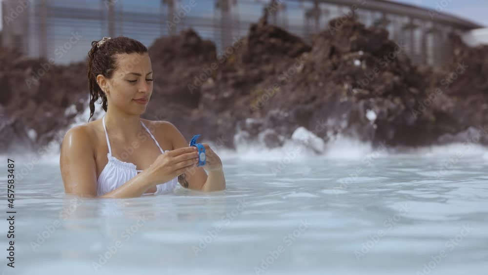 Woman Putting On Wrist Strap In Lagoon Geothermal Spa Woman Putting On Wrist Strap In Lagoon Geothermal Spa