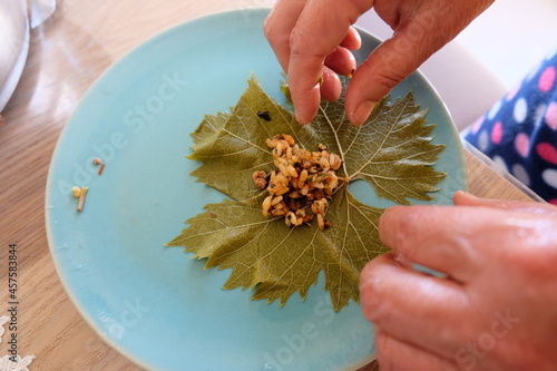 Process of making stuffed grape leaves with olive oil, selective focus. It is called 