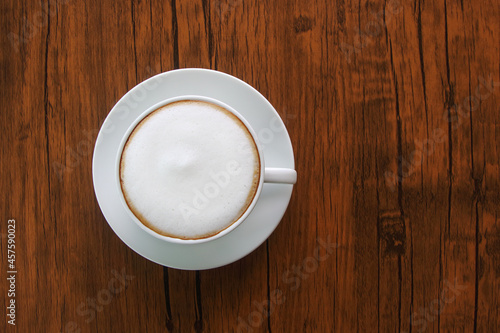 cup of latte or cappuccino on brown wooden floor